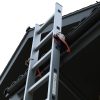 Een close-up van een RMBO® Ladder Klem die een ladder vastzet tegen de rand van het dak van een huis, met de lucht op de achtergrond.
